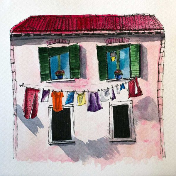 Casa rosa con ropa tendida